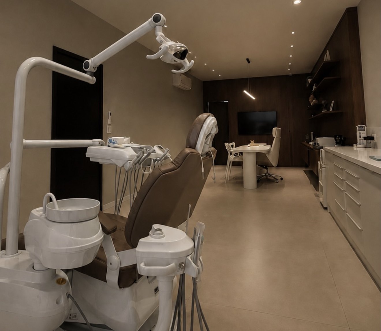 Consultório com cadeira odontológica e mesa de atendimento ao fundo